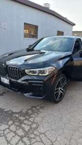 Detailer hand-washing car exterior, a step often compared in DIY vs professional car detailing