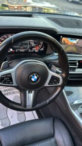 Professional detailer vacuuming car interior seats and carpet during a detail